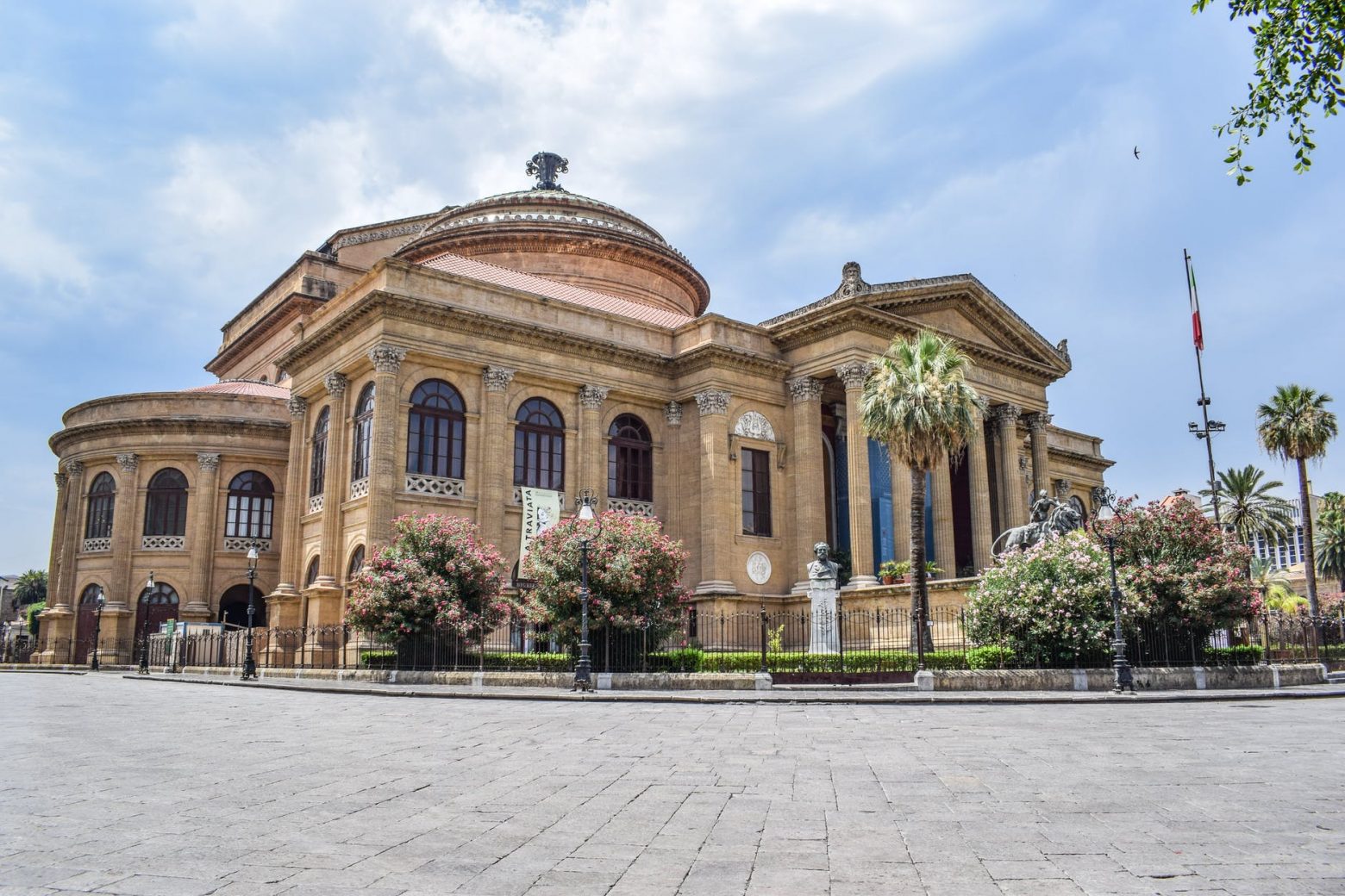 ancient building of opera house located on well groomed square against blue sky